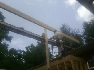 Carpenter setting a ridge beam over a new addition frame — Ice Dam Removal by Roofing Brothers in Pike