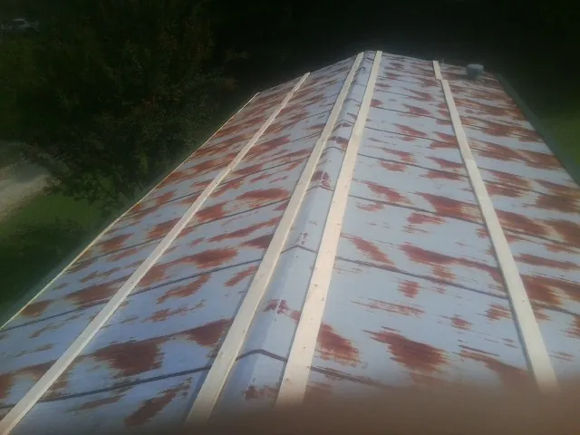 Rusted metal roof panels with new wood purlins before replacement — Storm Damage Roof Repair in Pike by Roofing Brothers