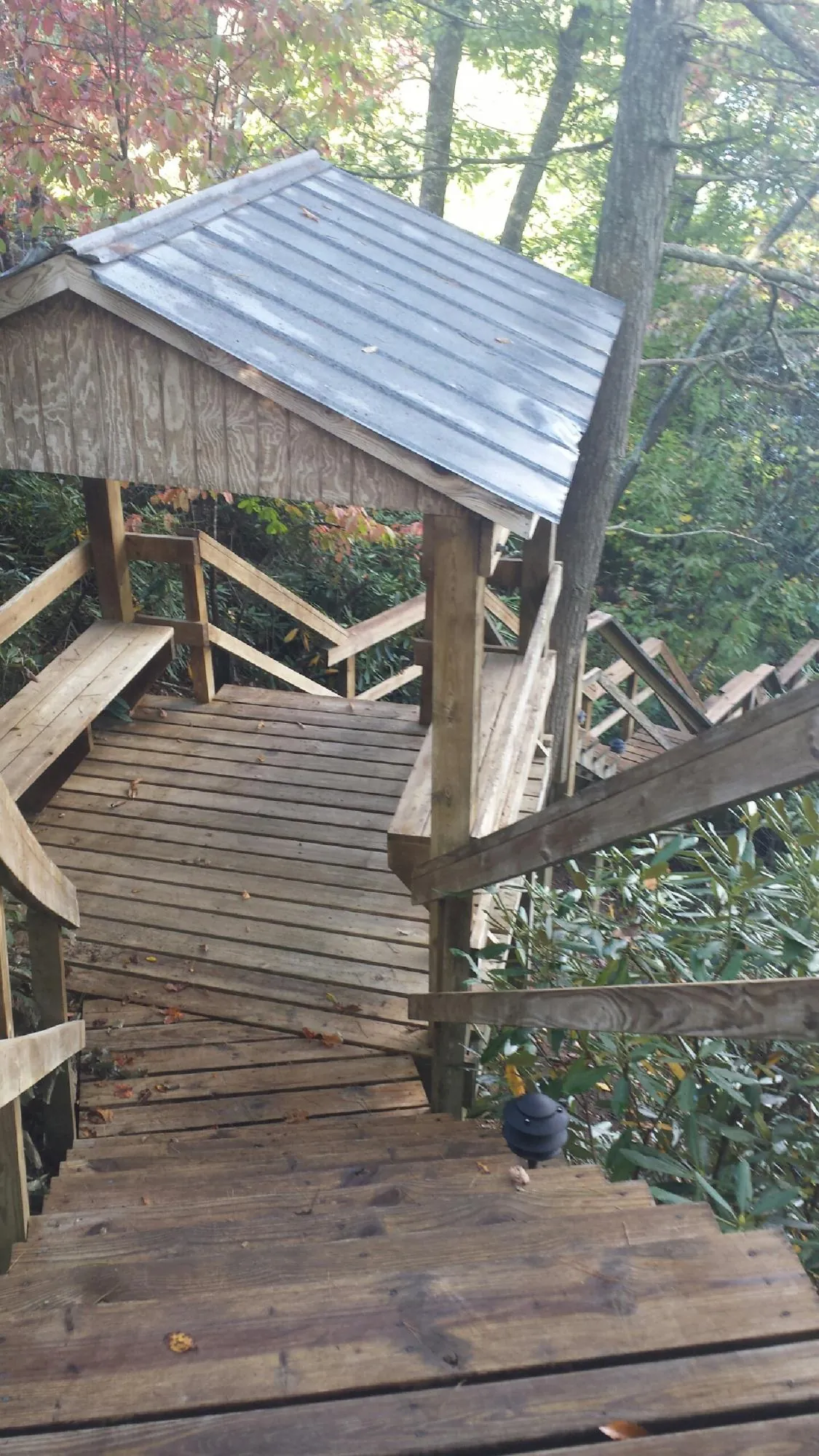 Metal roofed shelter over wooden steps on a wooded walkway — Skylight Repair & Installation work by our crew in Pike