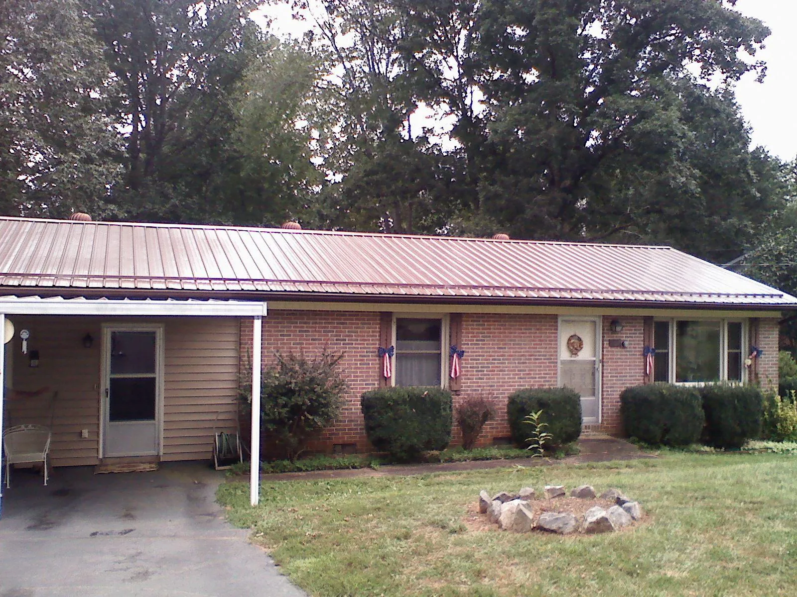 Bronze metal roof and carport on a brick ranch home — Roof Repair work by our crew in Pike